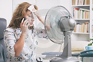 Woman suffers from heat in the office or at home