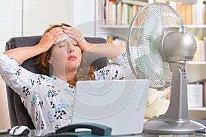 Woman suffers from heat in the office or at home