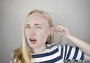 A woman suffers from pain in the ear. The auditory meatus hurts due to otitis media, cerumen plug, ear boil, or trigeminal