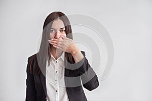 Woman in a suit, blocking her mouth, business compliance concept