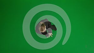 Woman in suit on green screen with chromakey. Blond businesswoman in formal outfit cheerfully dancing. Top view.