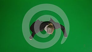 Woman in suit on green screen with chromakey. Blond businesswoman in formal outfit cheerfully dancing. Top view.
