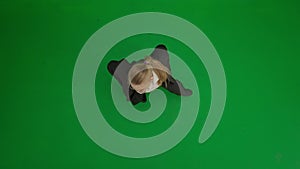 Woman in suit on green screen with chromakey. Blond businesswoman in formal outfit cheerfully dancing. Top view.