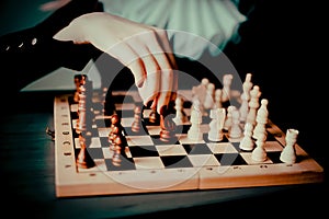 A woman in a suit with a jabot playing chess. It portrays a chess game, highlighting the strategic nature of the game. The