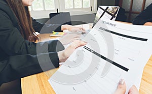 Woman in suit in office showing an insurance policy, Concept fill their laptop to get online