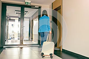 Woman with a suitcase in the corridor of the hotel