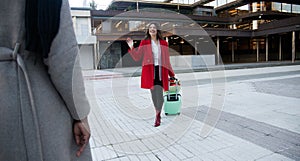 Woman with suitcase greeting her travel companion