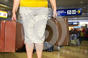 Woman with a suitcase is standing in the airport hall