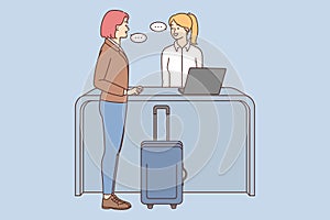 Woman with suitcase talk with administrator on reception