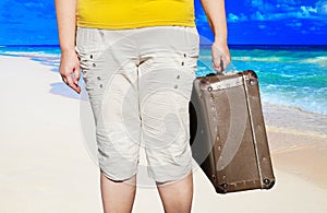 Woman with suitcases on the beach