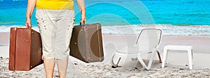 Woman with suitcases on the beach