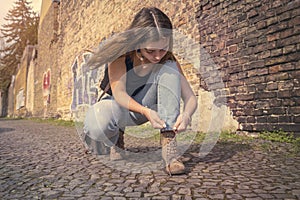 Woman in summer clothes ties her shoes