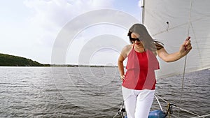 Woman in summer clothing enjoying voyage on sailing boat