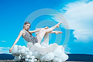 Woman in summer dress with party balloons. Fashion portrait of woman. inspiration and imagination. girl sit in sky