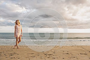 Woman in summer dress walking on beach
