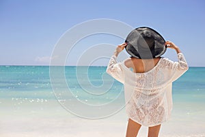Woman in summer hat on the beach