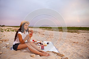 Woman in summer Picnic on the beach at sunset in the white plaid