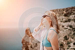 Woman summer travel sea. Happy tourist in sunglasses enjoy taking picture outdoors for memories. Woman traveler posing