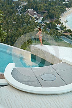 Woman on summer vacation at luxury resort near infinity pool