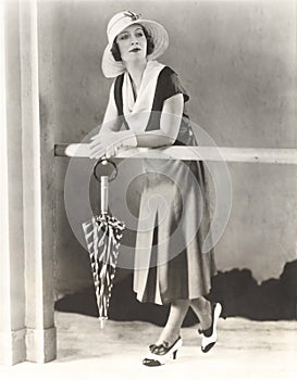 Woman in sun hat and cowl neck dress