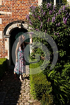 Woman sun lilac syringa wall door, Groot Begijnhof, Leuven, Belgium