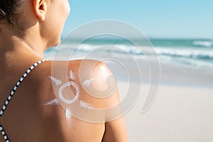 Woman with sun shaped sunscreen on shoulder