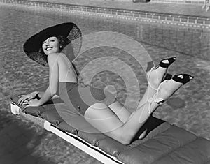 Woman sunbathing at pool photo