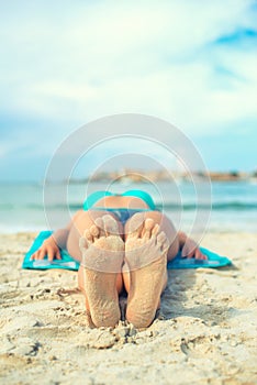 Woman sunbathing on sand.