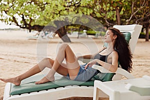 woman sunbed smiling sand sea beach lying ocean lifestyle resort tan