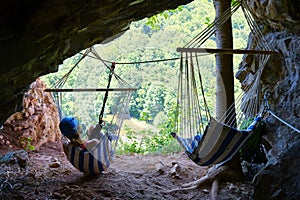 Woman at Suncuius via ferrata, resting in a hammock located in a small cave on the route, with beautiful views of Crisul Repede.