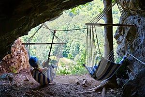 Woman at Suncuius via ferrata, resting in a hammock located in a small cave on the route, with beautiful views of Crisul Repede. photo