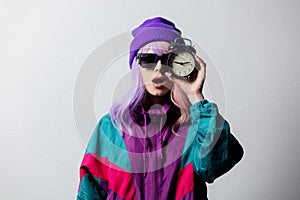 Woman in sunglasses with alarm clock and 80s sportsuit