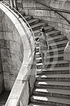 Woman in sunglasses and dress walking down stairs