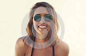 Woman, sunglasses and portrait on vacation at beach in summer, mockup and plain background. Travel, adventure and girl