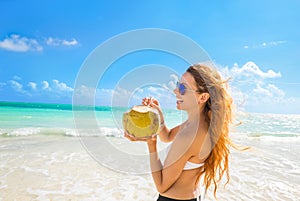 Woman with sunglasses on tropical beach enjoying ocean view