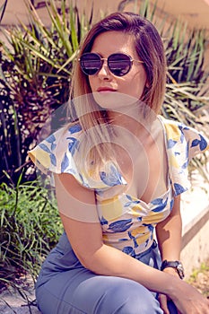 woman with sunglasses wearing trendy summer clothes outside