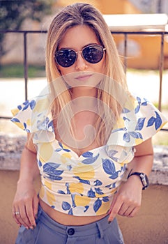 woman with sunglasses wearing trendy summer clothes outside