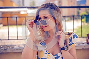 woman with sunglasses wearing trendy summer clothes outside