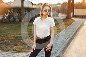 Woman with sunglasses in a white polo shirt in black jeans