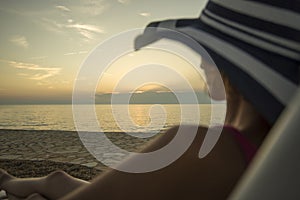 Woman with sunhat overlooking the ocean photo