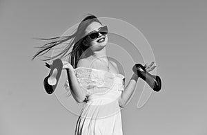 Woman on sunny morning blue sky. Summer holidays. Model tender summer dress. Freedom. Girl in sunglasses copy space