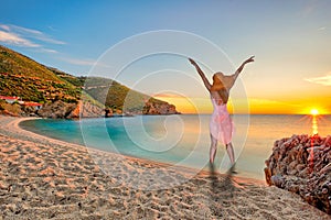 A woman at the sunrise at the beach Kalamos in Evia, Greece