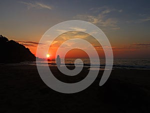woman watching the sunrise on the beach photo