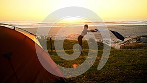 Woman, sunrise and yoga mat at beach in morning for stretching balance, camping adventure or tent. Female person, nature