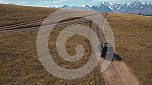 Woman in sunroof SUV ride on hill dirt road aerial view