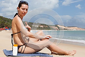 woman with sunscreen on the beach