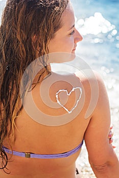 Woman with sunscreen tan lotion on her tanned back