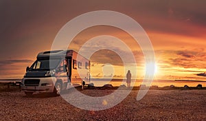 Woman at sunset  with mobile home on the beach photo