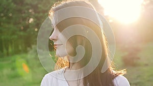 Woman at sunset straightens hair. Slow motion.