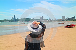 Woman on the sunshine beach looking at the sea